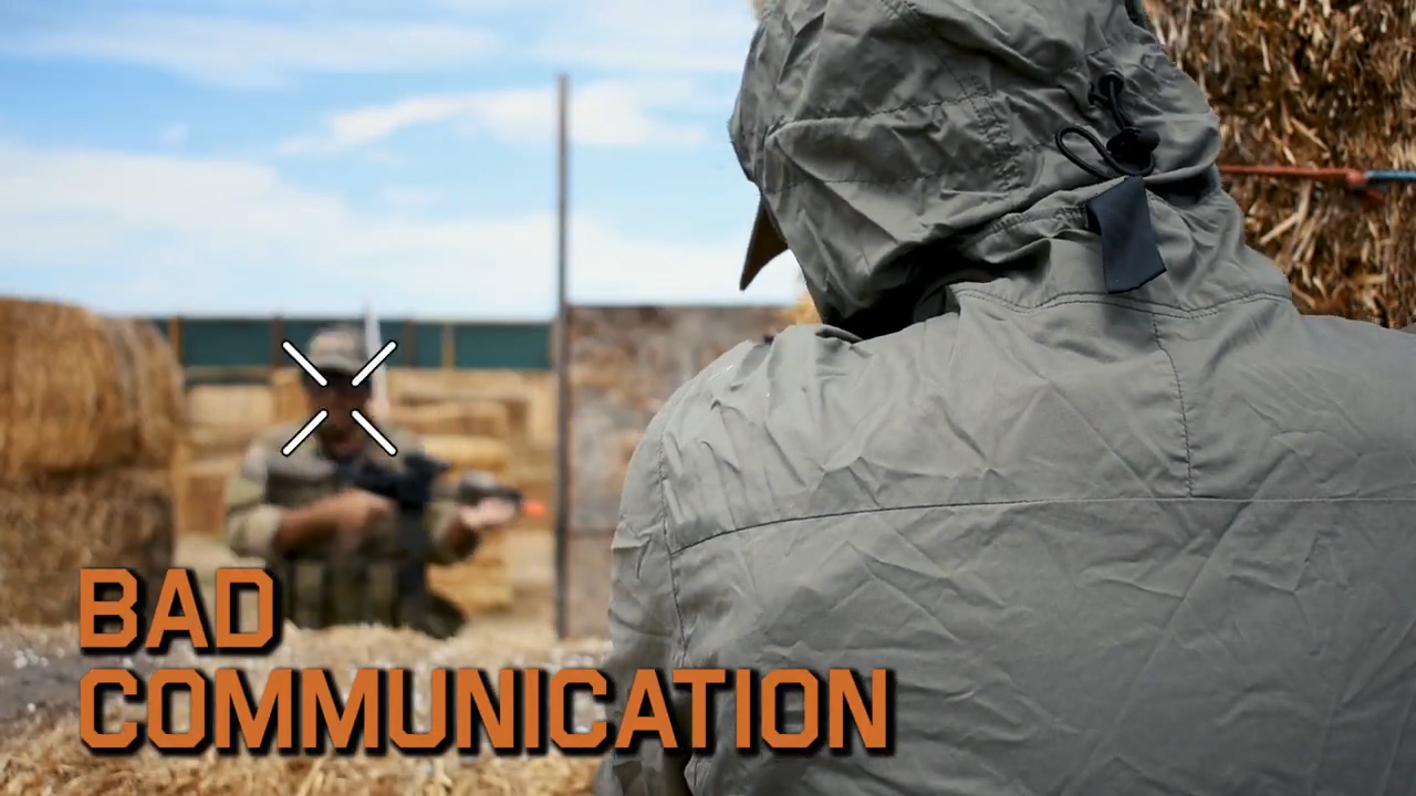 Over-the-shoulder view of an airsoft player in the foreground with "BAD COMMUNICATION" text, focusing on another player making a hand signal, crossed out to indicate a miscommunication.